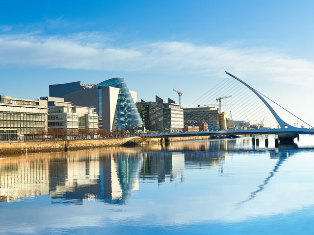 Modern buildings and offices on Liffey river in Dublin bridge on the right is a famous Harp bridge 