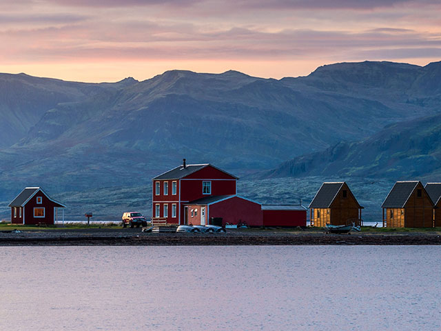 Line of hostel cottage with mountain range background during sunrise at Eskifjorour Iceland 