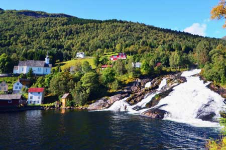 Waterfall and houses in the background, Norway