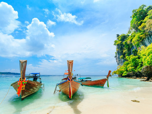 Traditional boats in the clear blue sea of Phuket, Thailand