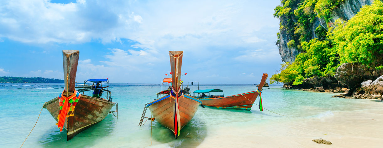 Traditional boats in the clear blue sea of Phuket, Thailand