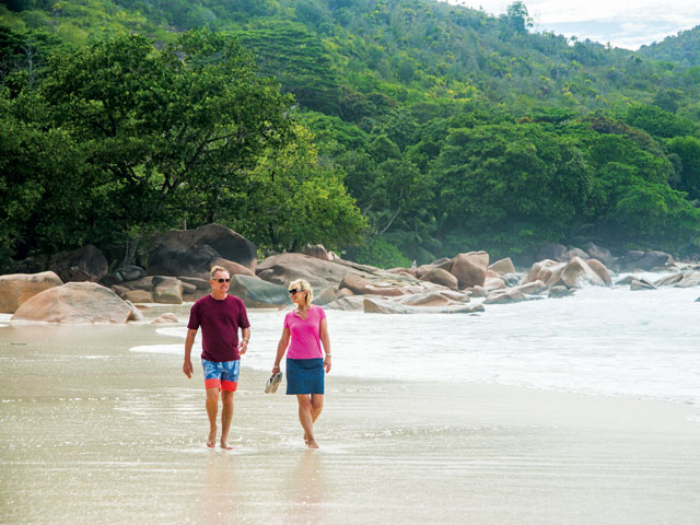 Couple walking along the beach in Praslin Island