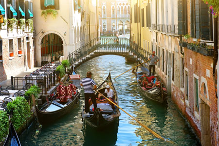 Gondala rowing down a canal in Venice, Italy