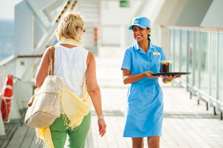 Waitress with drinks passing a guest on deck