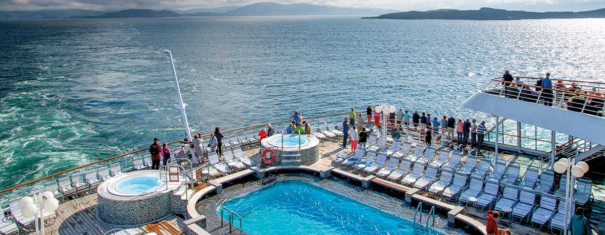 Balmoral cruising, guests enjoying swiming pool on deck