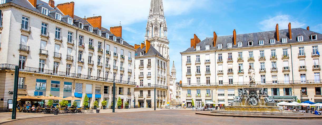 View on Royal square with fountain and church tower, Nantes, France