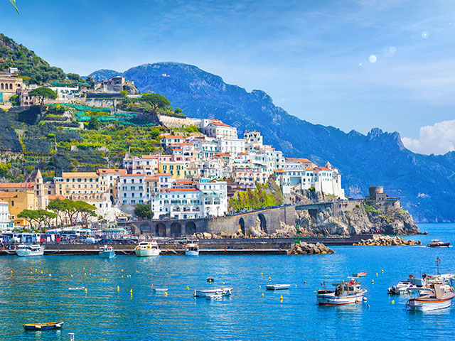 Panoramic view of beautiful Amalfi on hills leading down to coast, Campania, Italy.