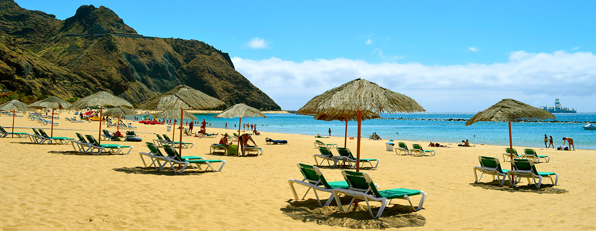 Las Teresitas with yellow sand, umbrellas, lounges and palm trees, Santa Cruz, Tenerife
