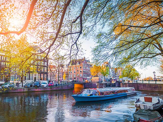 Spring scene in Amsterdam city. Tours by boat on the famous Dutch canals