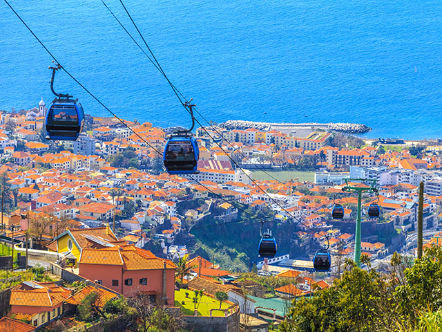 Traditional cable car transporting tourists above Funchal city, Madeira