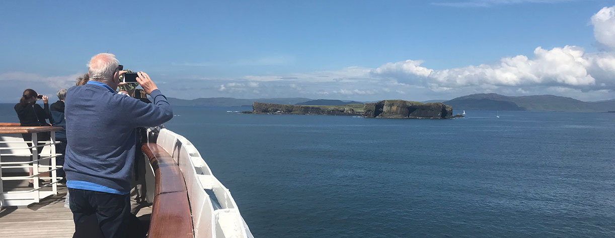 Passengers looking out to Fingals cave from onboard, UK