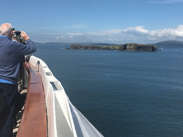 Passengers looking out to Fingals cave from onboard, UK