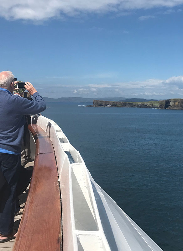 Passengers looking out to Fingals cave from onboard, UK