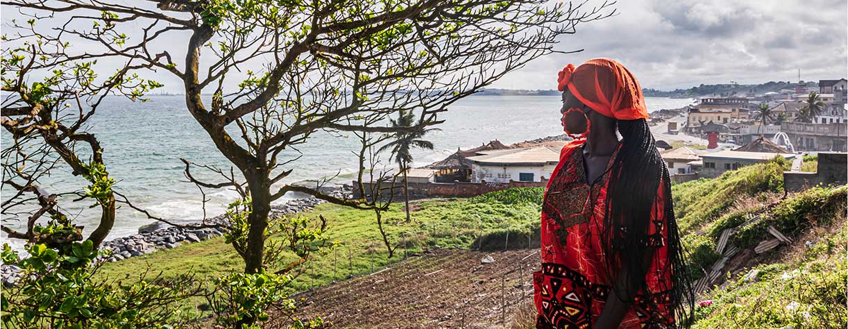 African woman looks out over the sea in Takoradi, located in Ghana