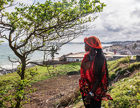 African woman looks out over the sea in Takoradi, located in Ghana