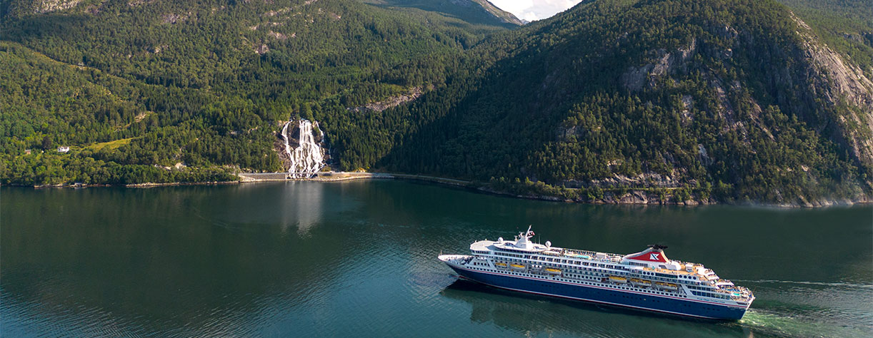 Balmoral cruising by Furebergsfossen waterfall, Norway Balmoral cruising by Furebergsfossen waterfall, Norway