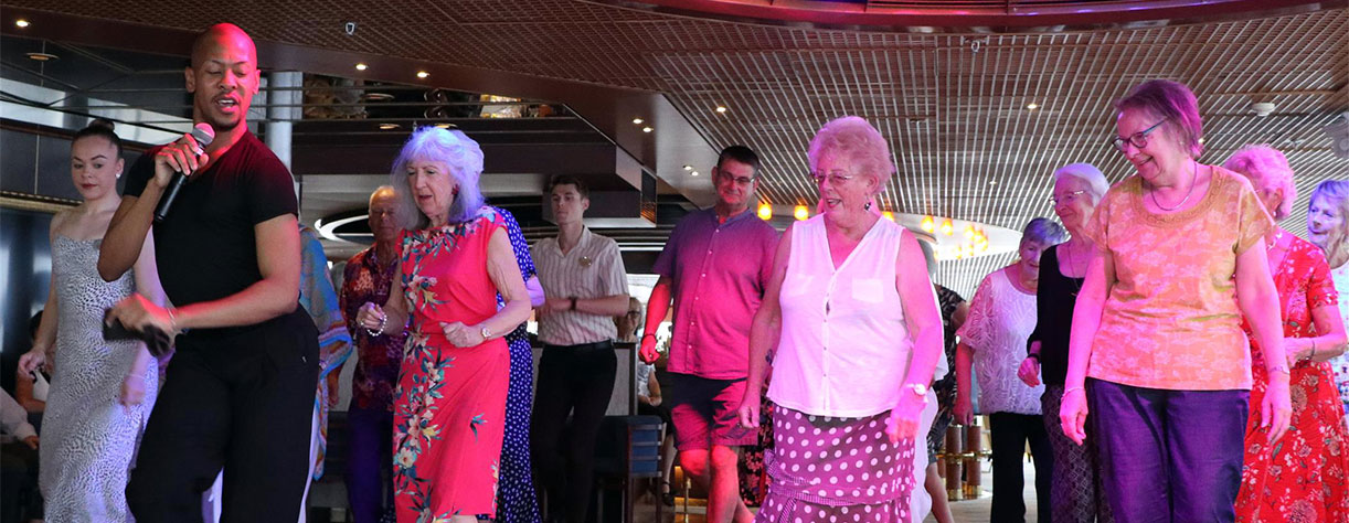 Guest learning to Salsa dance on board