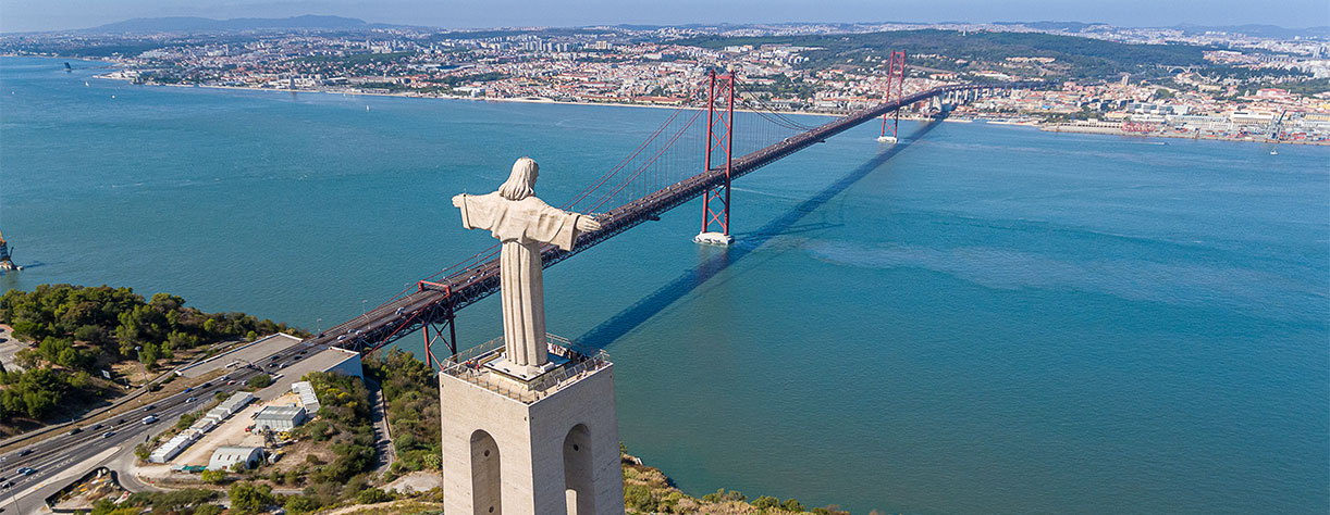 Panorama from sky, a 25 de Abril Bridge and a statue of Jesus Christ. Lisbon.