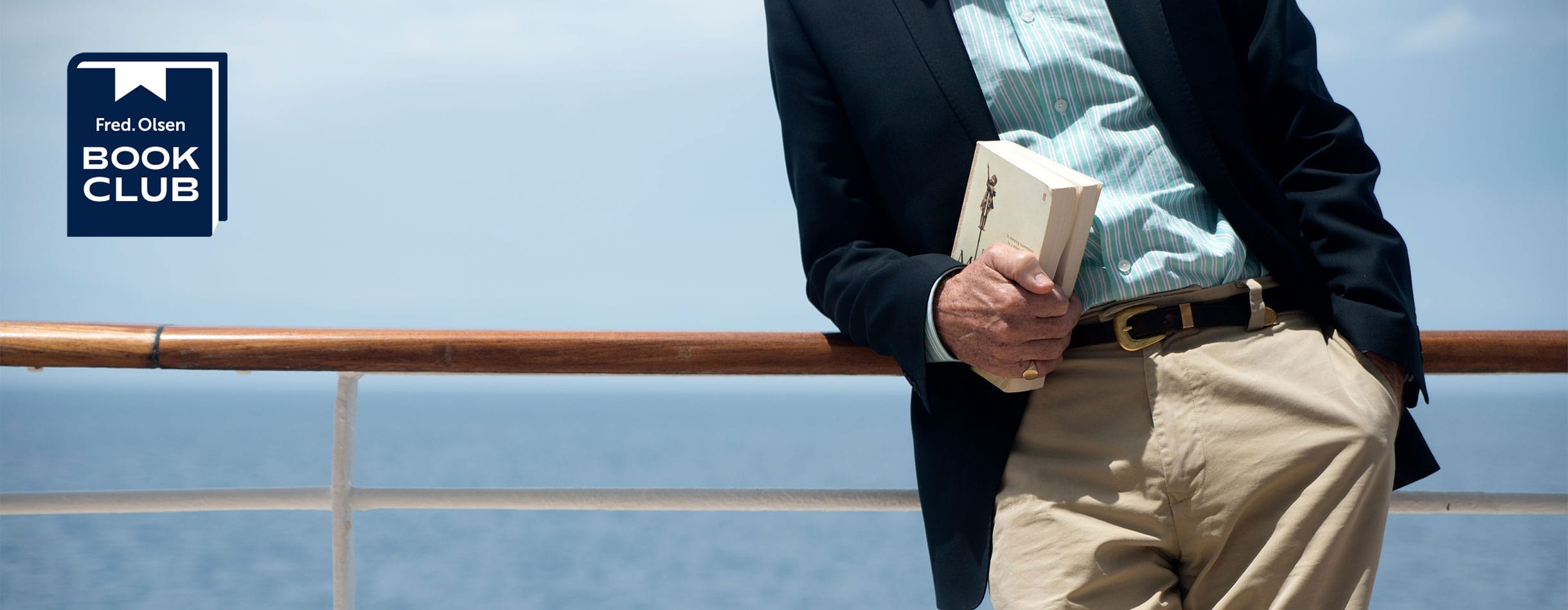 Man standing on deck with book in hand