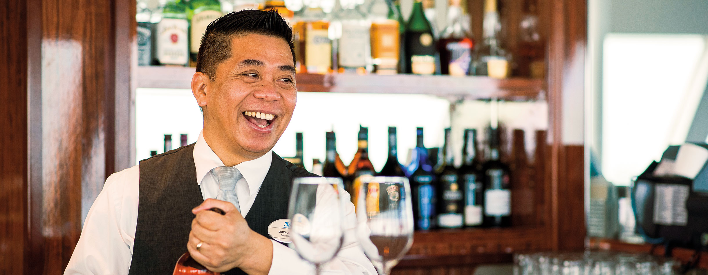 Waiter at the bar smiling 