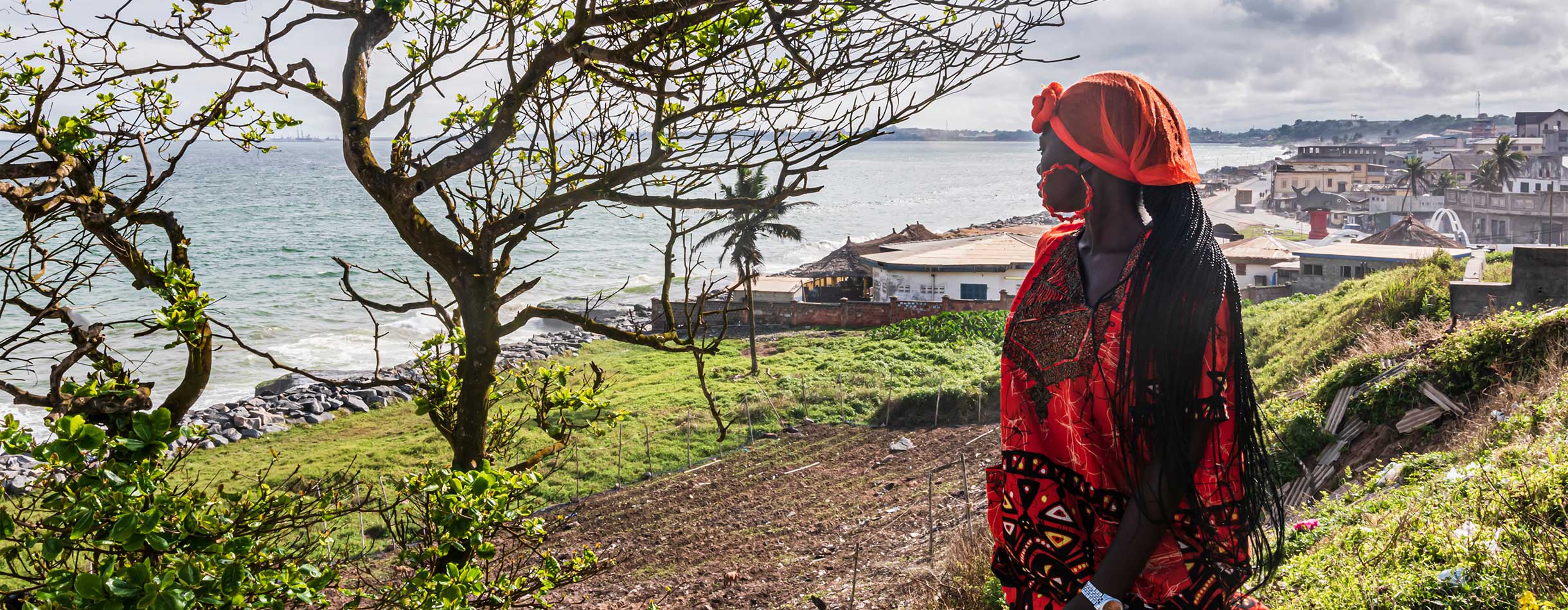 African woman looks out over the sea in Sekondi-Takoradi, located in Ghana