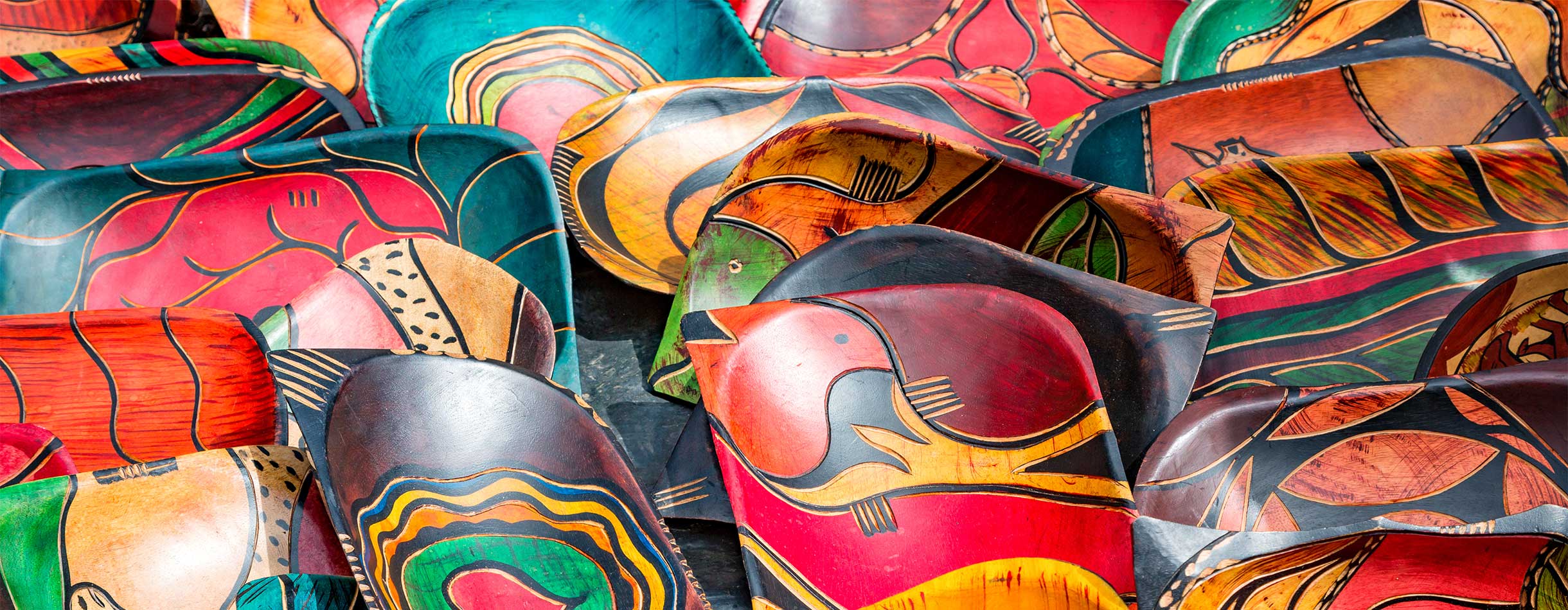 Rows of carved, hand painted wood bowls at a market in South Africa.