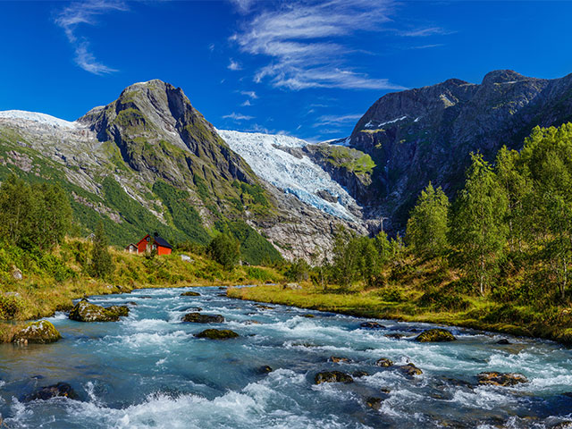 A stunning view of the Briksdal Glacier near Olden, Norway, with icy blue formations and surrounding mountains.