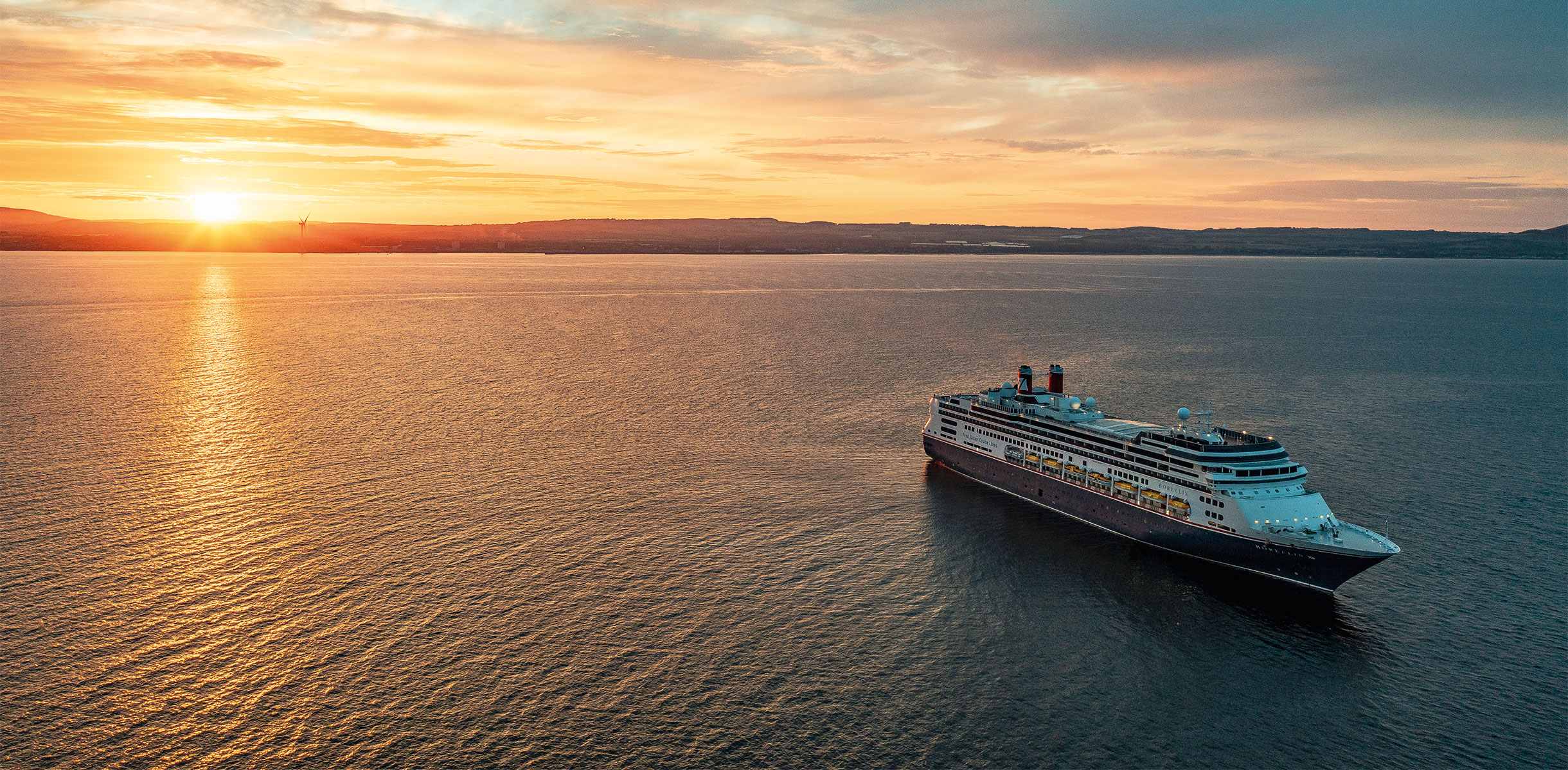 Borealis at sea at sunset