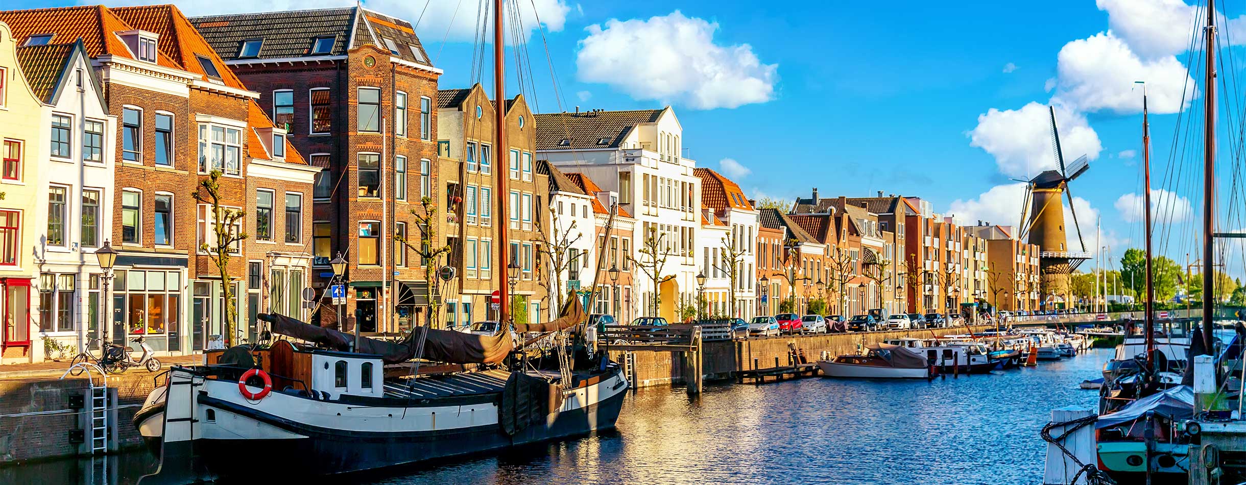 Old historic district Delfshaven with windmill and houseboats in Rotterdam