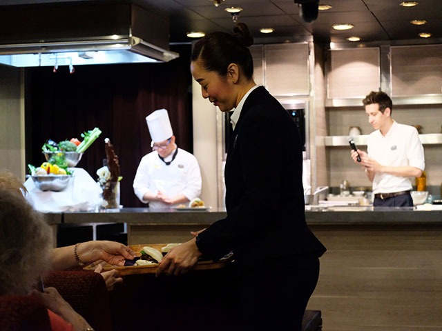 Crew team member handing out dish from Treat of the Region