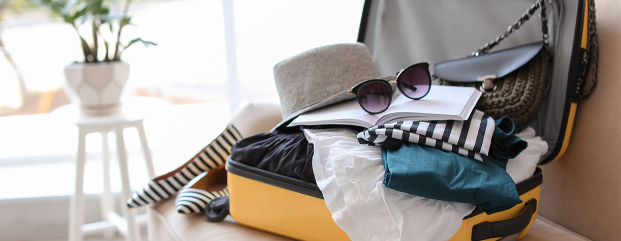 Open suitcase with summer clothes