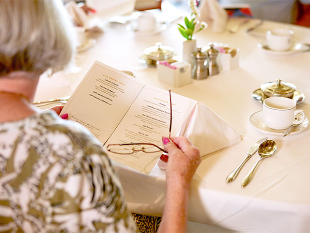 Guest looking at breakfast menu in the main restaurant, Borealis