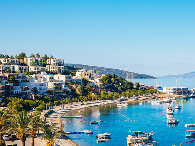 View of Bodrum Beach, Aegean sea, traditional white houses, marina, sailing boats, yachts, Turkey.