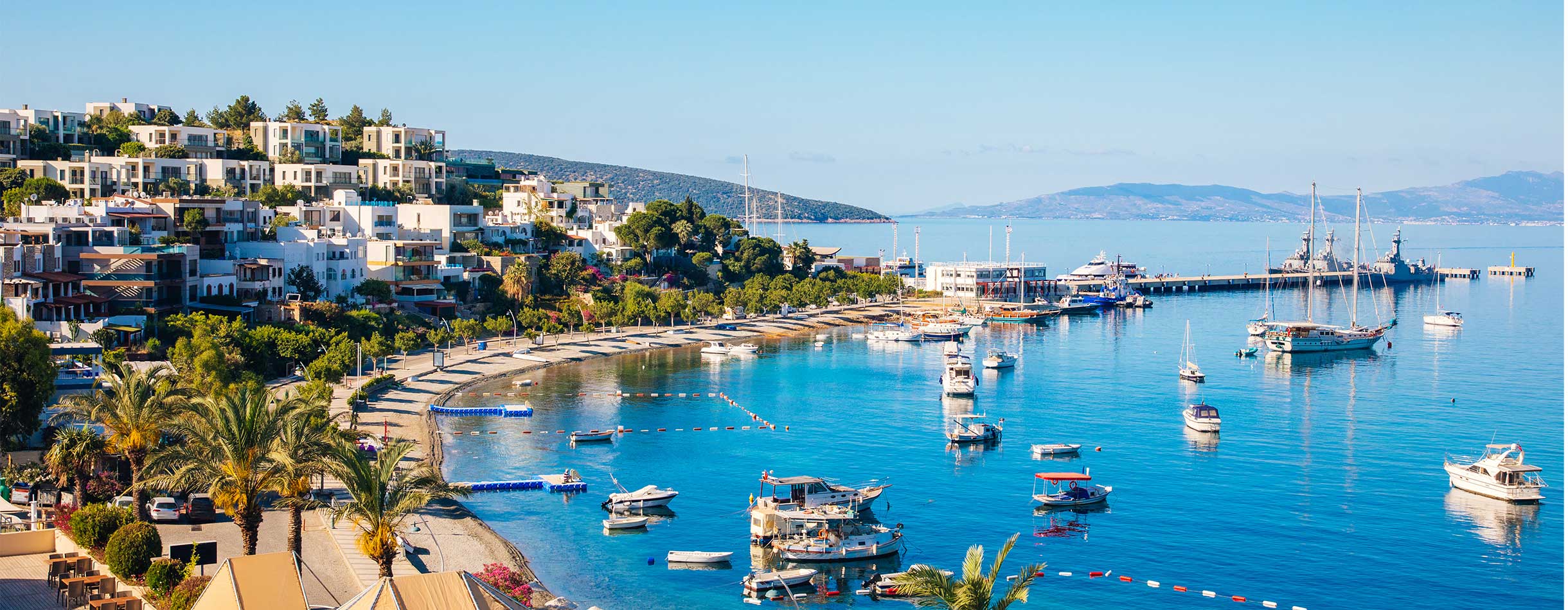View of Bodrum Beach, Aegean sea, traditional white houses, marina, sailing boats, yachts, Turkey.