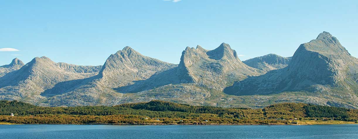 Part of Norwegian mountain range called "seven sisters" over a body of water