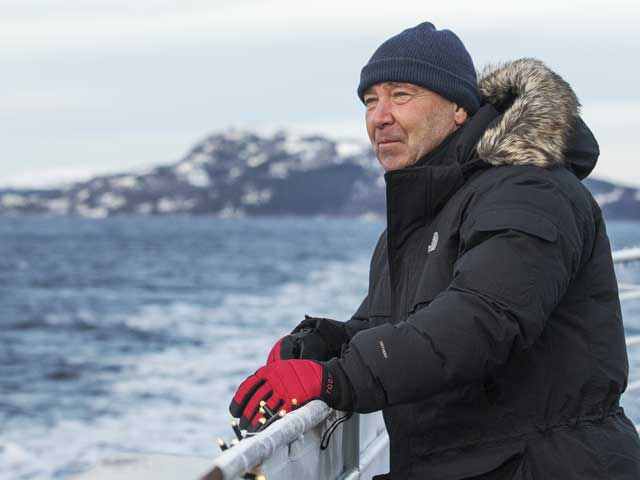 Man looking out on deck dressed for winter