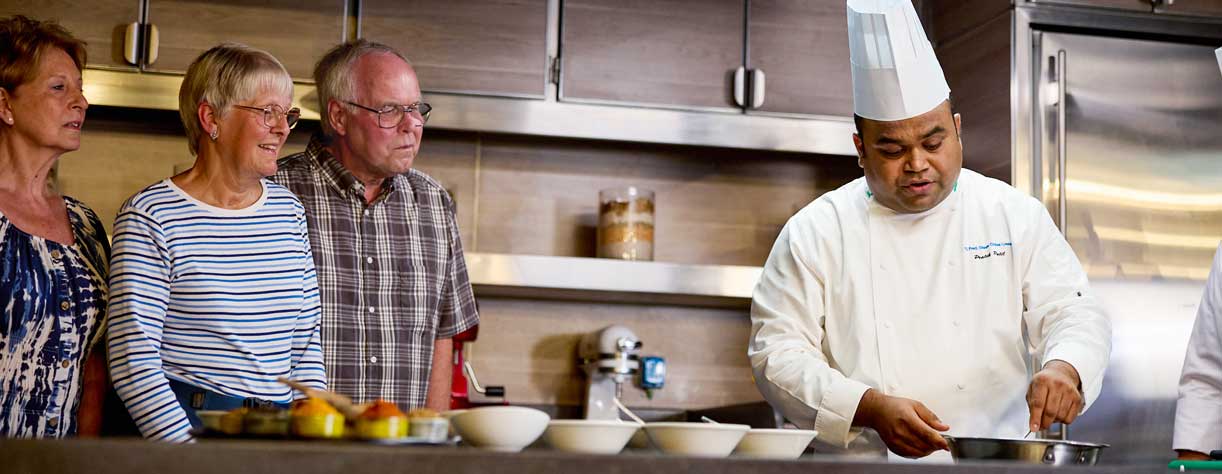 Chef showing guests how to cook a regional dish