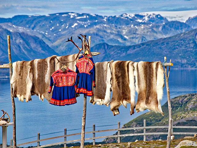 Sami clothing on washing line with reindeer skins