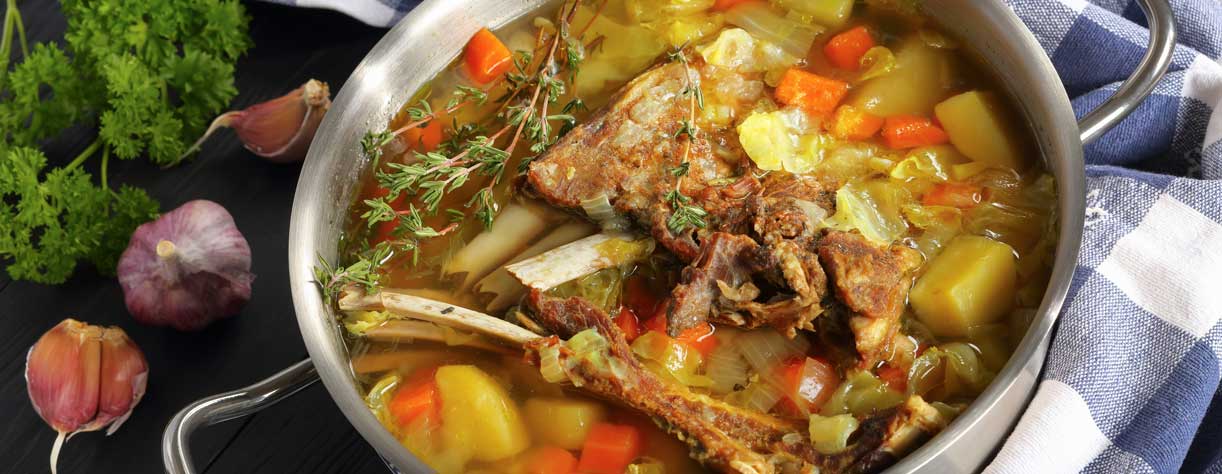 Icelandic Lamb winter hot Soup with vegetables and spices in a stainless steel casserole pan