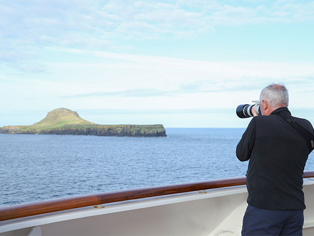 Guest taking pictures of Dutchman's cap, Scotland, Scenic cruising