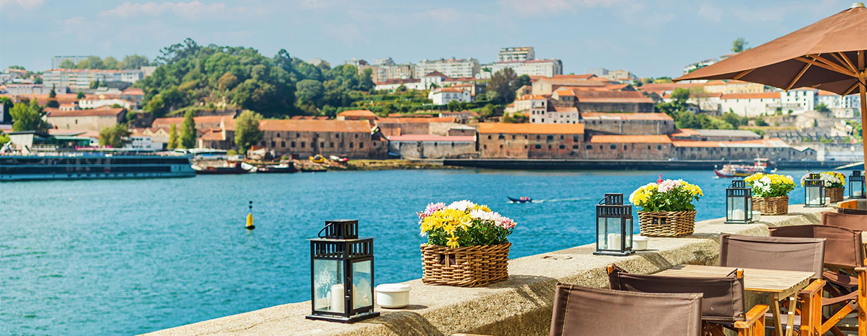 Café tables and chairs on the banks of the Douro River in Porto