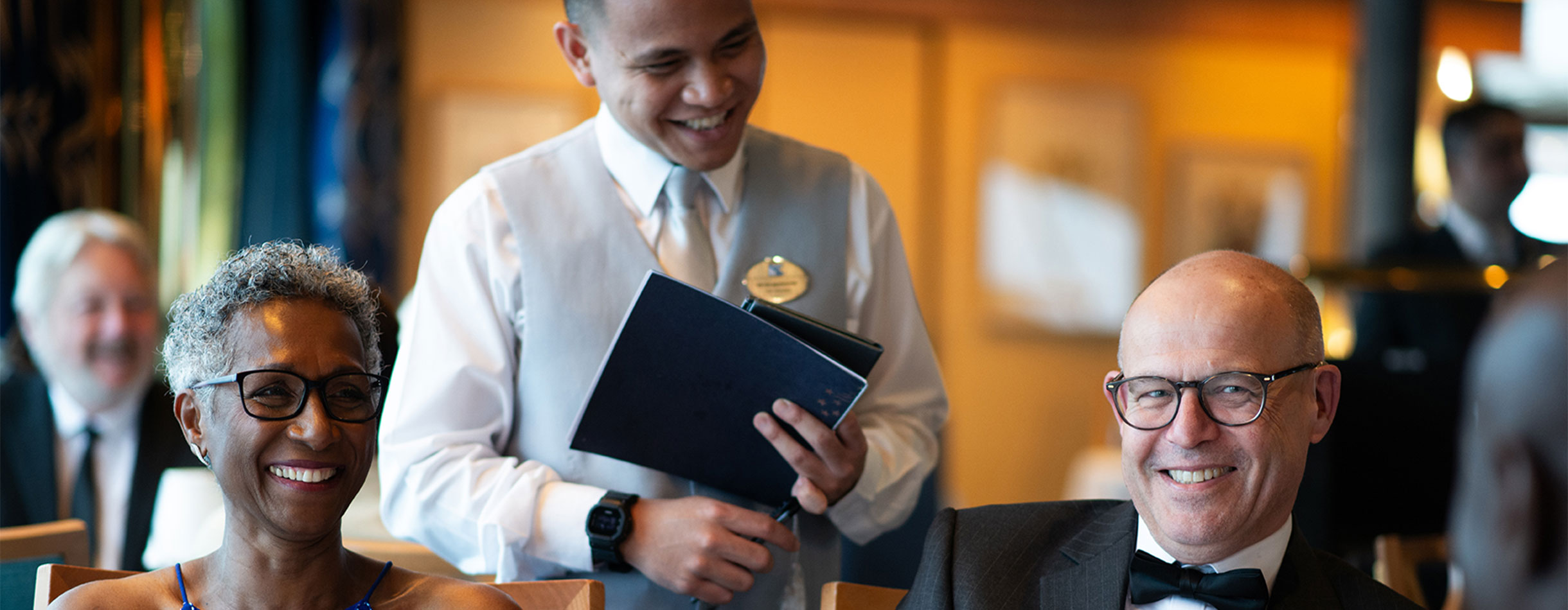 Guests with waiter on formal evening at the main restaurant, Bolette