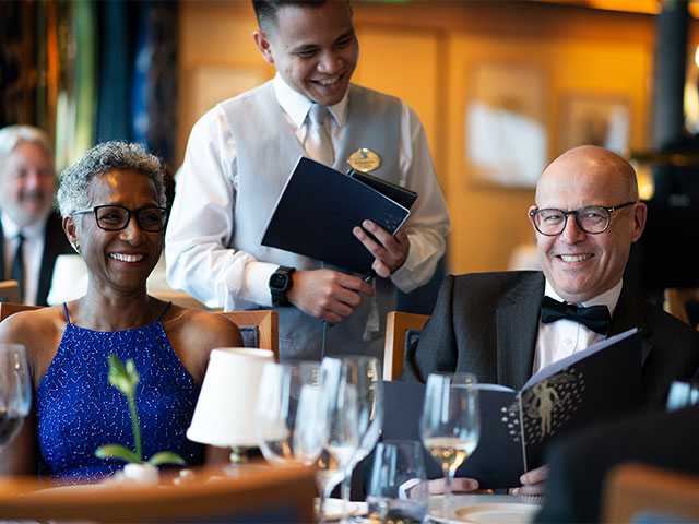 Guests with waiter on formal evening at the main restaurant, Bolette