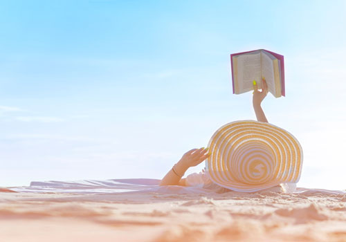 A lady reading a book on holiday