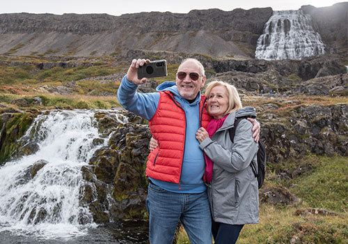 Couple taking selfie at Dyjandi waterfalls in Iceland Couple taking selfie at Dyjandi waterfalls in Iceland