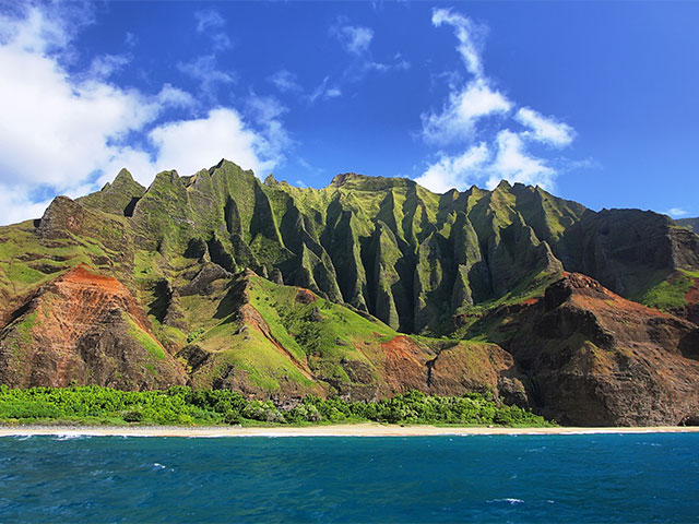 Jagged hills from catamaran at the dramatic Na Pali coast , Hawaiian islands