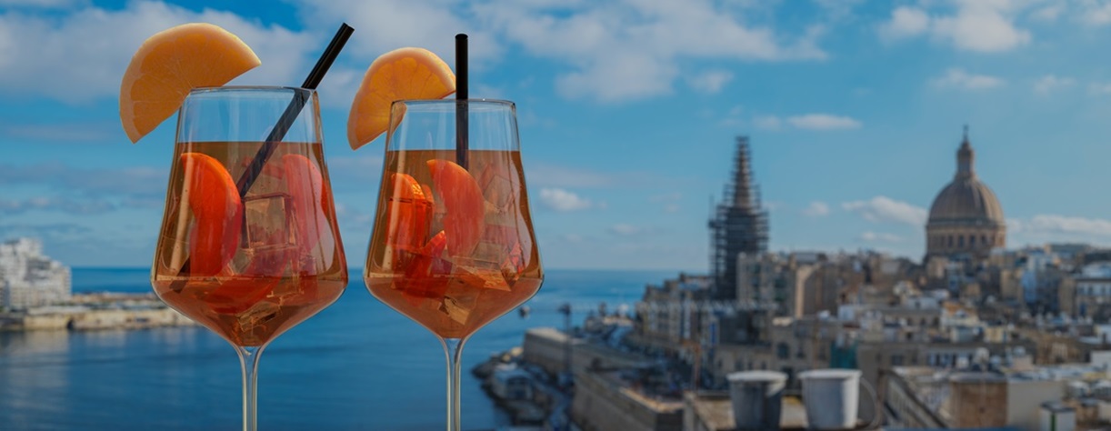 Two cocktails with a view of Valletta in the background