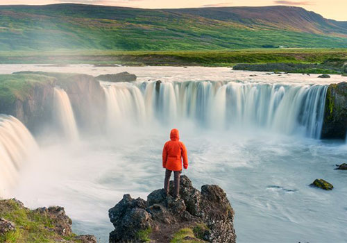 Person looking over Godafoss Waterfall, Iceland Person looking over Godafoss Waterfall, Iceland