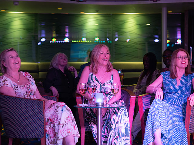 Guests watching evening entertainment in the Neptune lounge on Balmoral