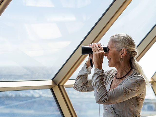 Guest looking through binoculars in the Observatory